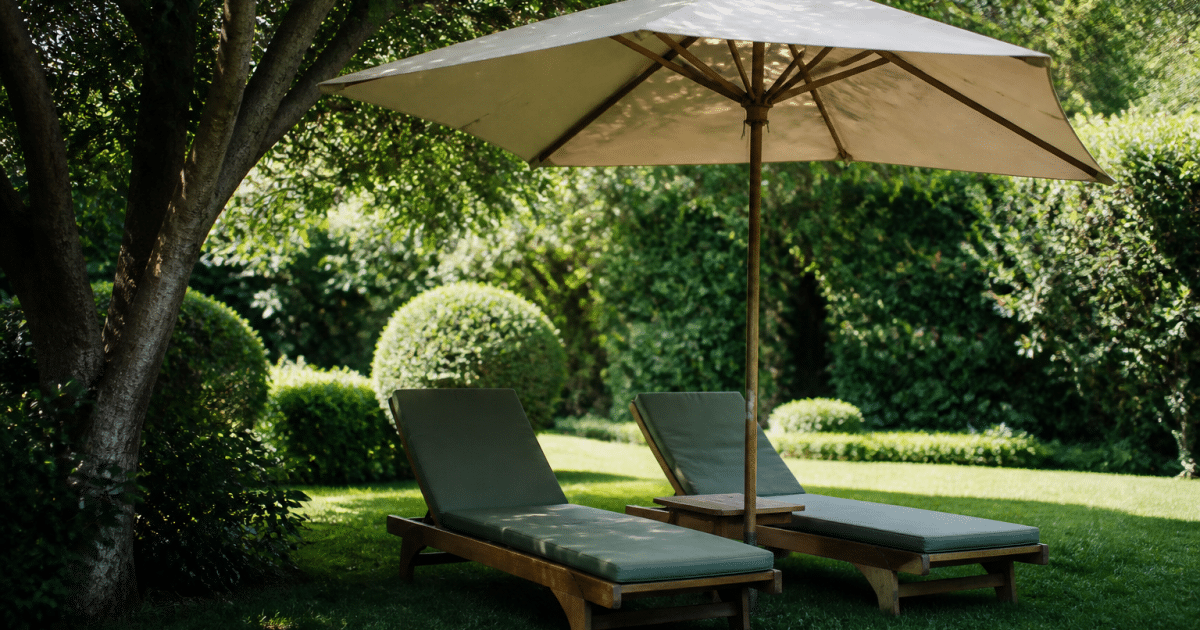 Chaises longues placees sous parasol dans jardin verdoyant