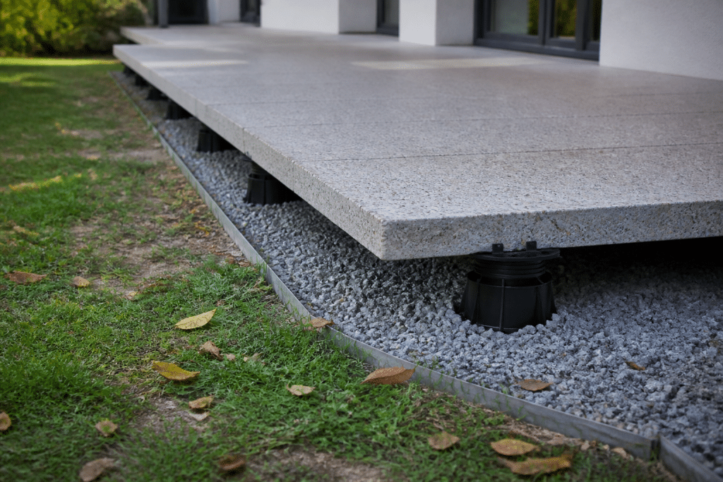 Dalle beton surélevée avec couche gravier drainant visible