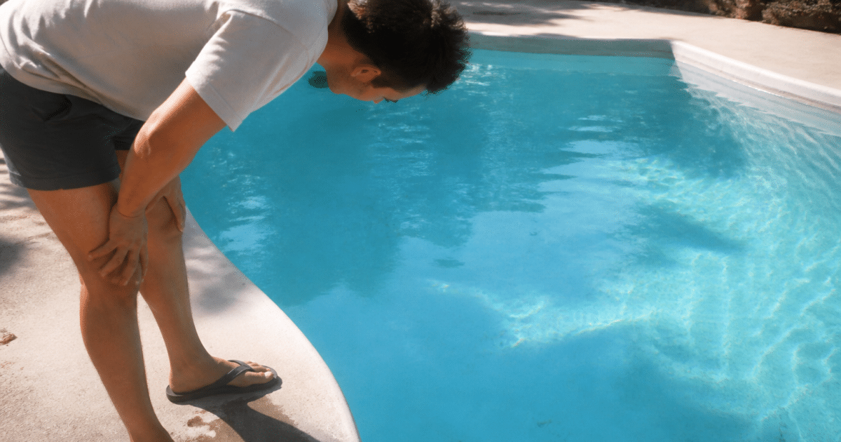 Homme penche inspectant le fond bleu piscine