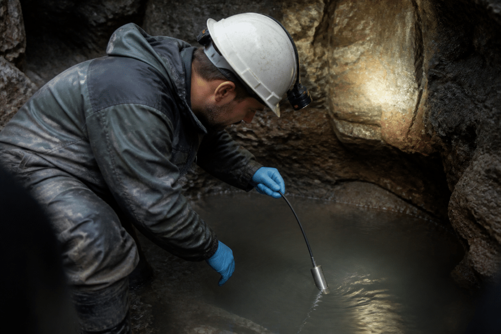 Technicien mesure nappe phréatique avec équipement spécialisé souterrain
