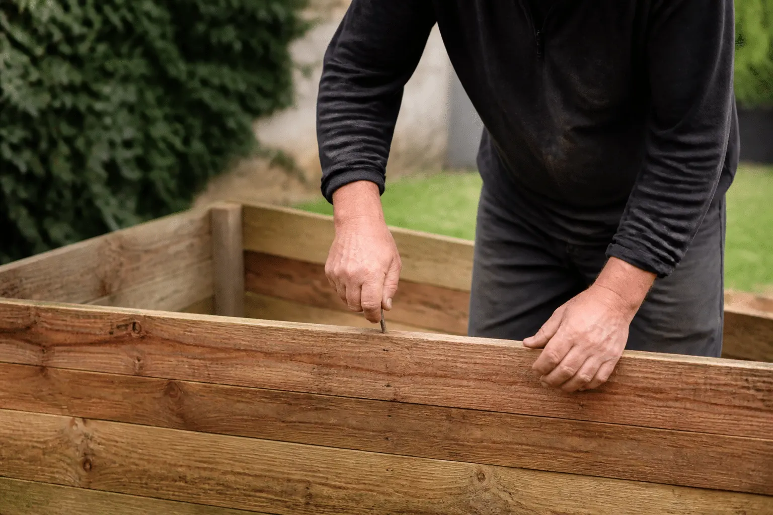 Mains construisant bac en bois avec planches clouées