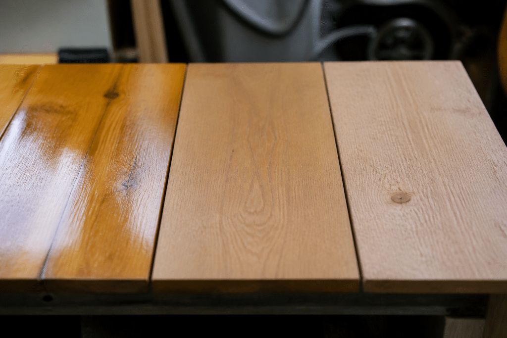 Trois surfaces de bois montrant vernis brillant, cire mate, brut naturel
