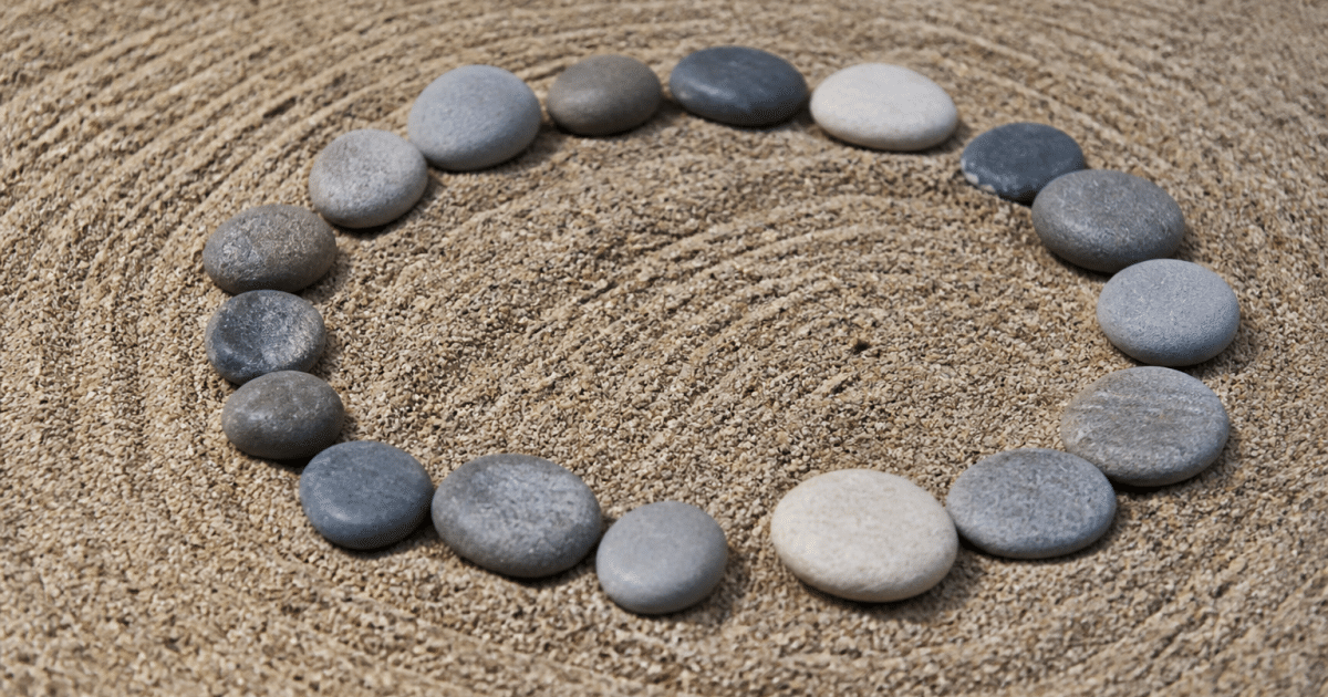 Pierres lisses disposees en cercle sur sable ratisse