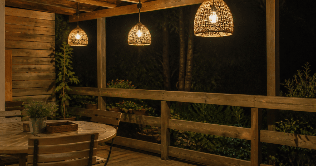 Lampes suspendues eclairant une terrasse en bois la nuit