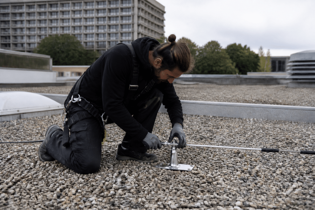 Ouvrier installe ligne de vie sur toiture