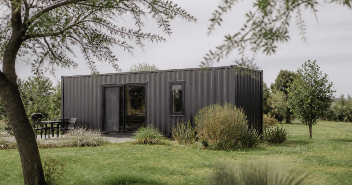 Maison container metallique isolee dans campagne verte