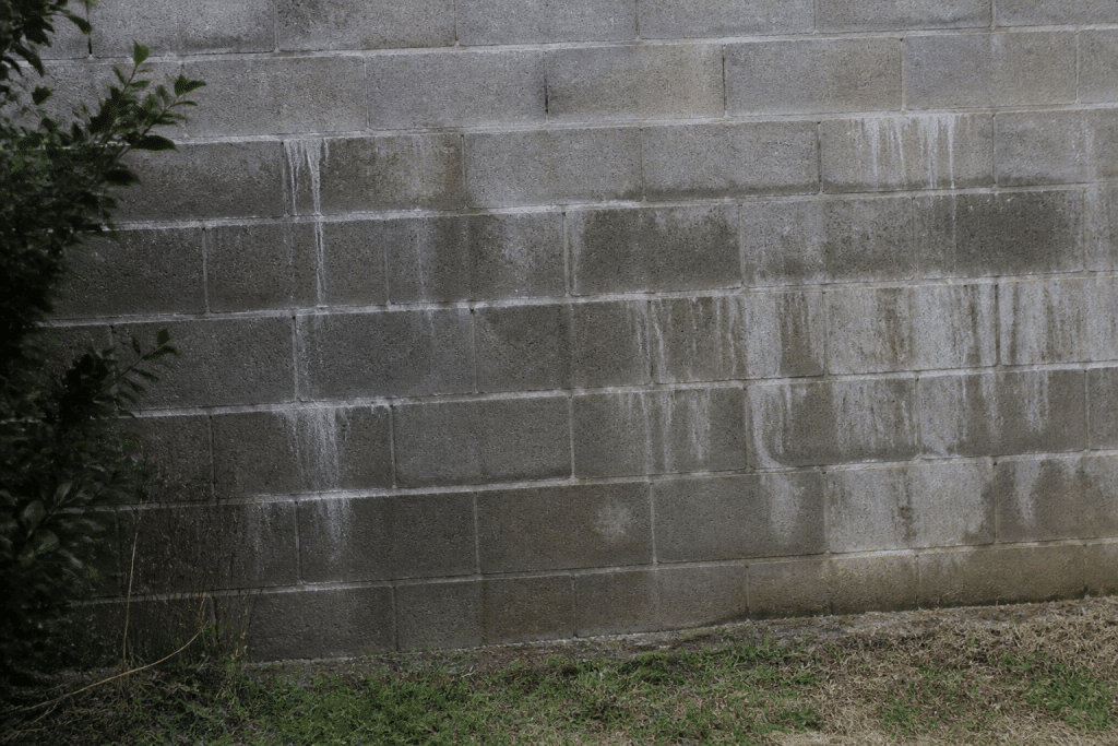 Mur parpaing gris avec traces humidite et infiltration eau