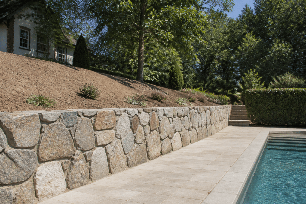 Mur de pierre retenant terre pente piscine terrain
