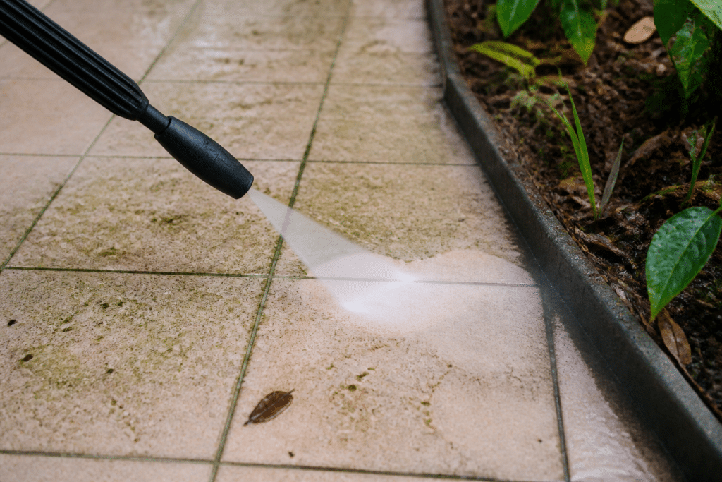 Buse nettoyeur projette eau sur carrelage sale avec joints verts