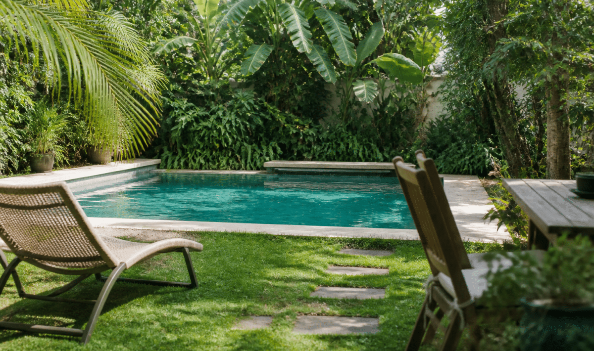 Piscine entouree de plantes vertes et mobilier exterieur
