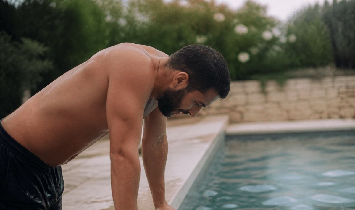 Homme penche vers l'avant au bord de la piscine