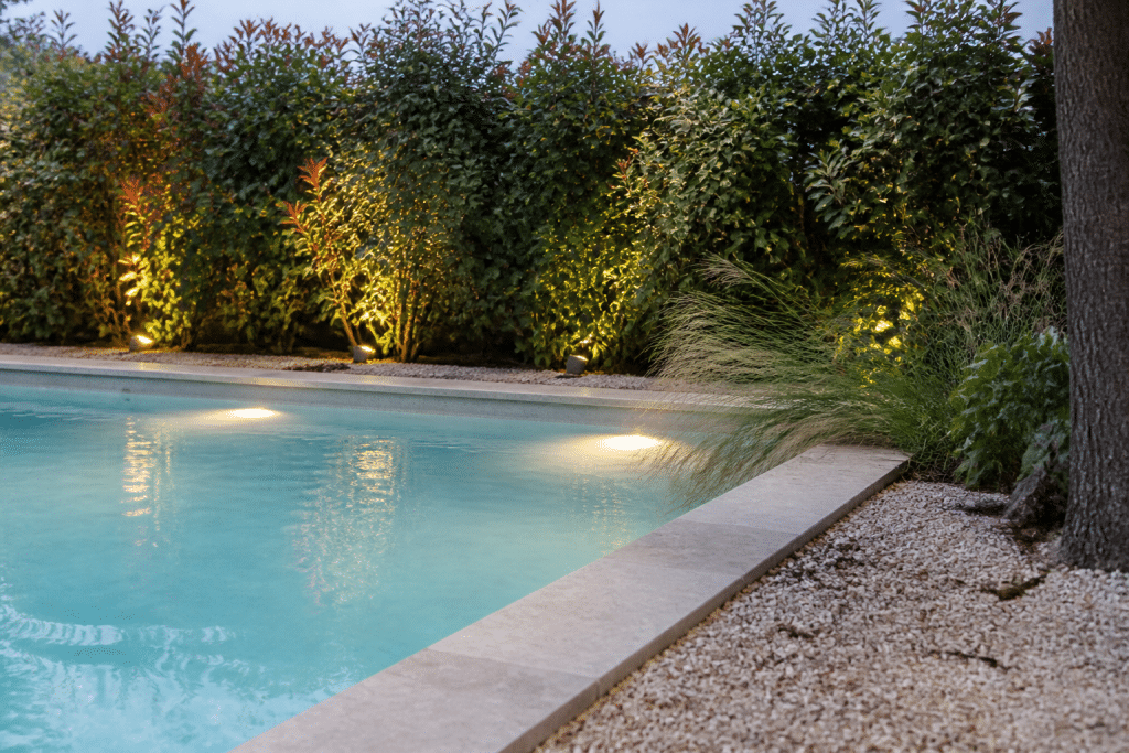 Piscine illuminée spots LED margelles brise-vue végétal