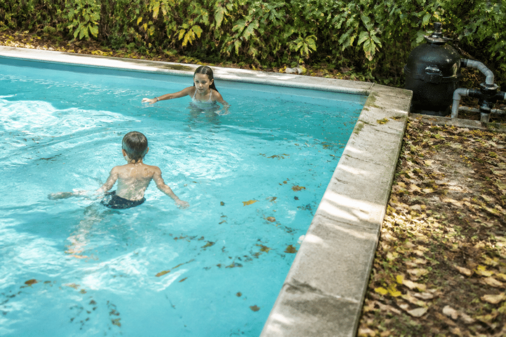 Piscine avec feuilles, baigneurs et filtre visible