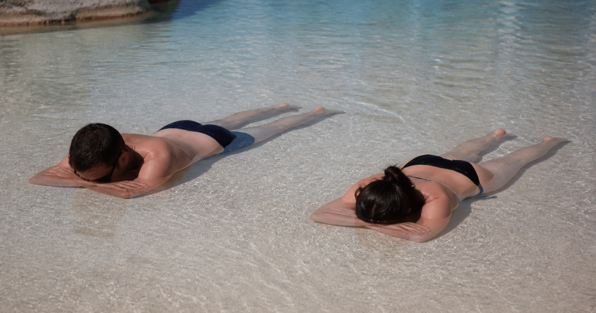 Baigneurs allonges sur banc sable peu profond piscine