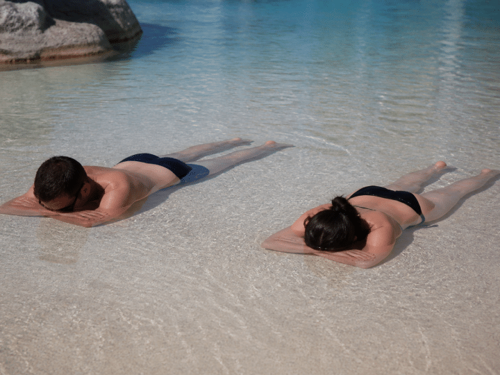 Baigneurs allonges sur banc sable peu profond piscine
