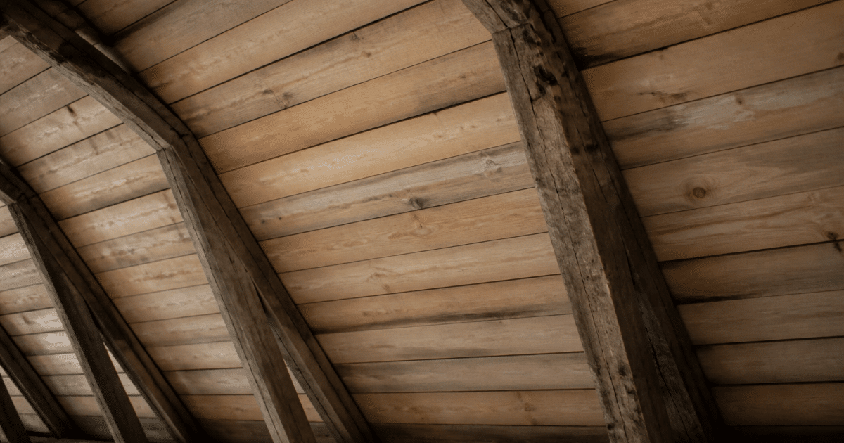 Planches de bois posees horizontalement sous charpente mansardee