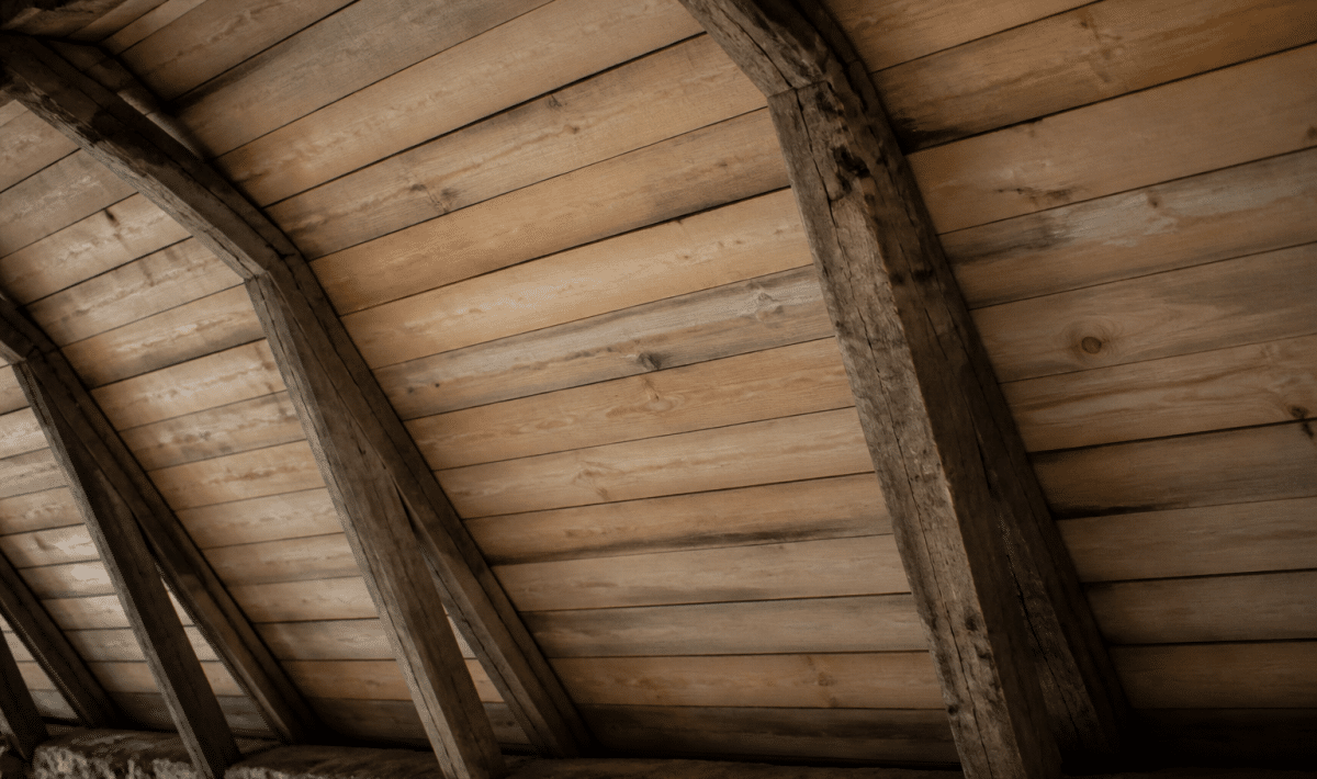 Planches de bois posees horizontalement sous charpente mansardee