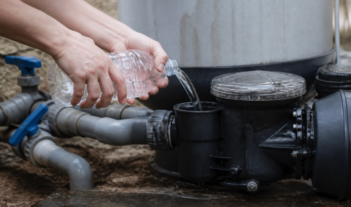 Mains versant eau dans orifice pompe piscine