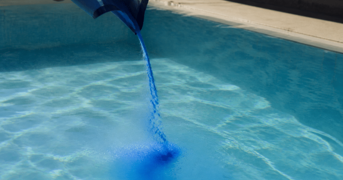 Poudre bleue versee dans eau piscine cristalline