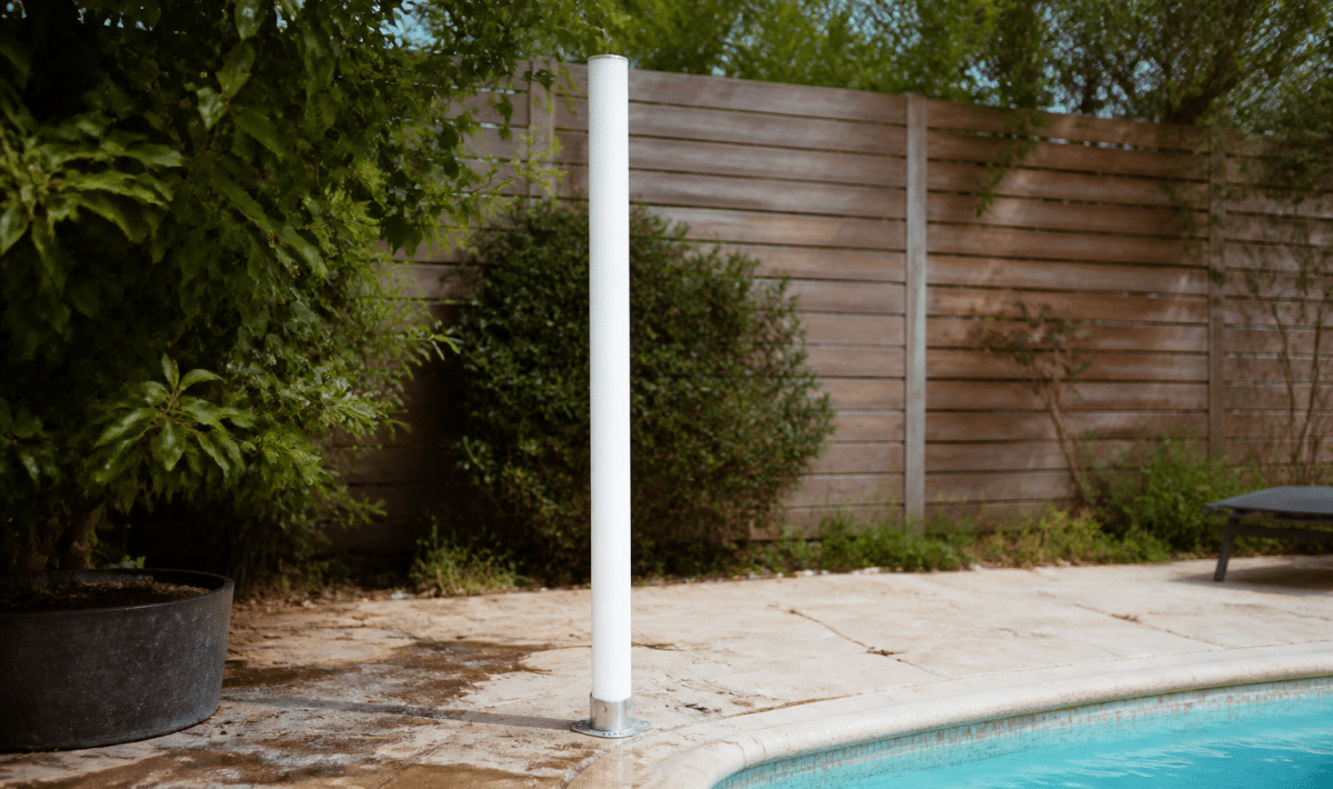 Tube vertical blanc installee au bord piscine