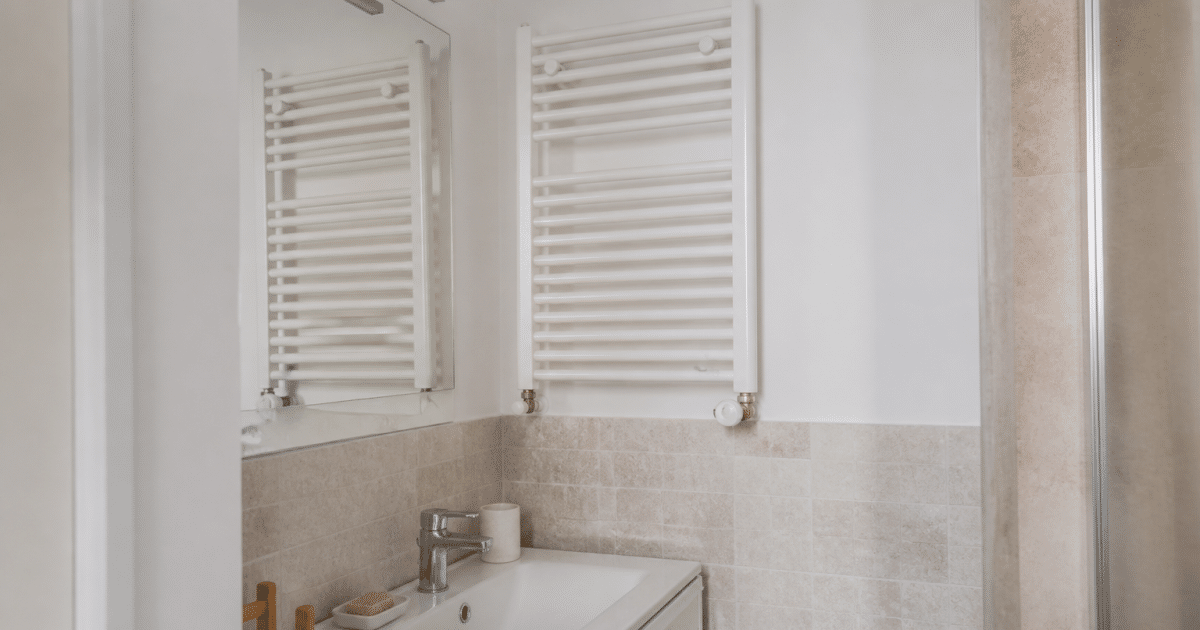 Radiateur mural blanc fixe au-dessus lavabo carrelage