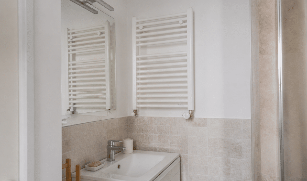 Radiateur mural blanc fixe au-dessus lavabo carrelage