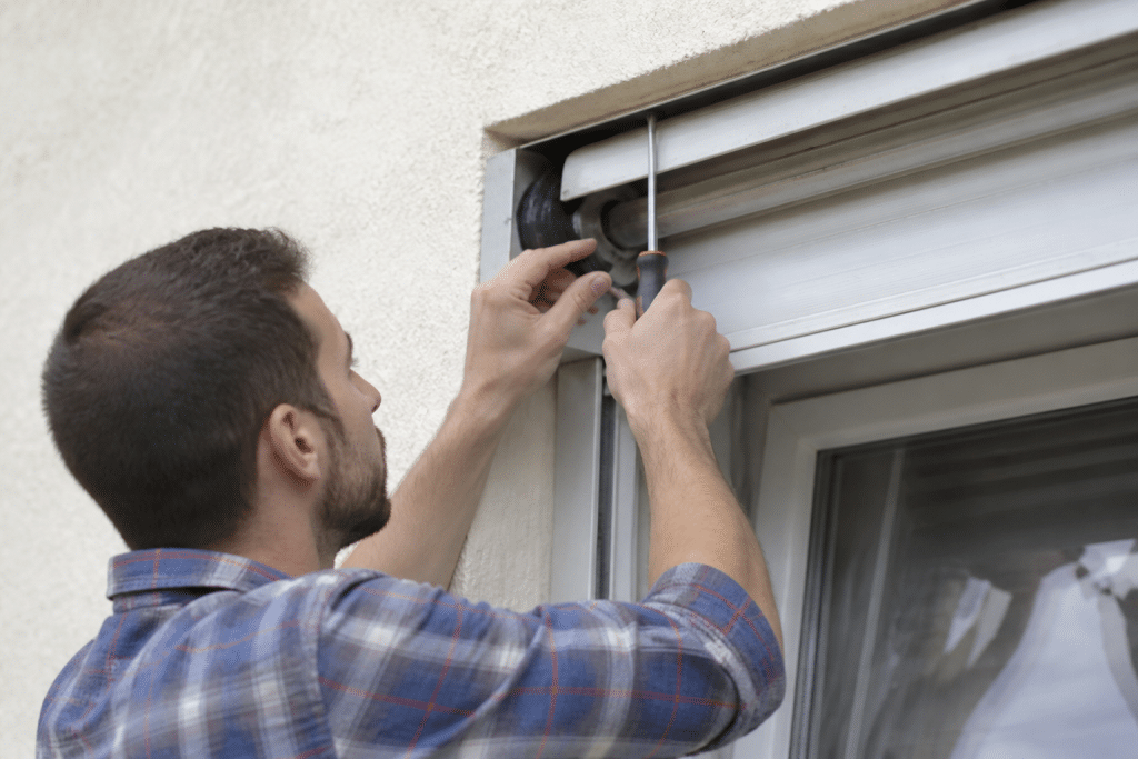 Technicien réparant moteur volet roulant avec outils professionnels