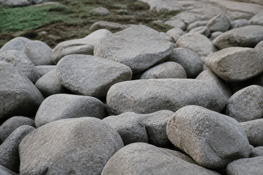 Roches grises uniformes empilees naturellement sur terrain.