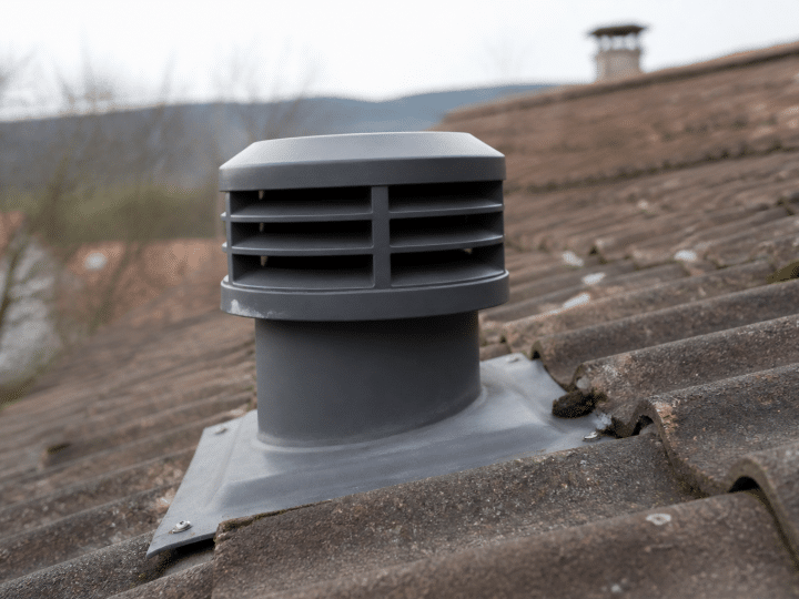 Sortie ventilation cylindrique grise fixee sur toit pente