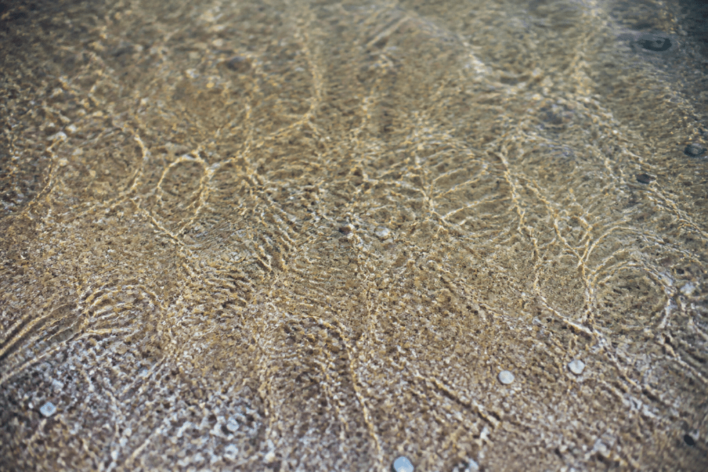 Surface texturee de plage sous eau claire et brillante