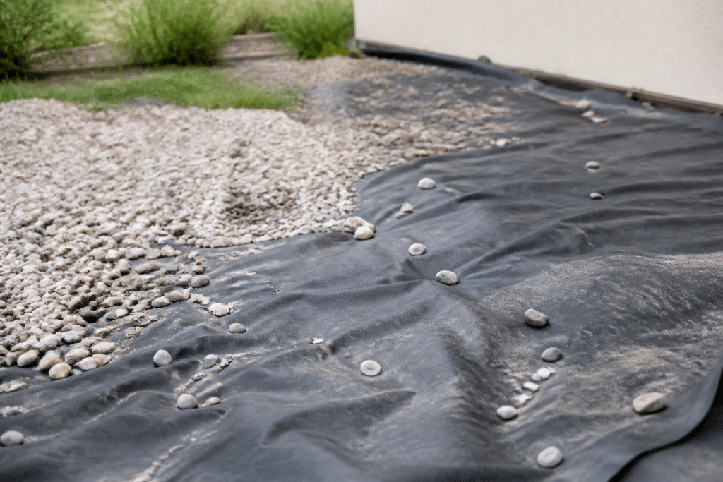 Terrain avec graviers et géotextile noir posé