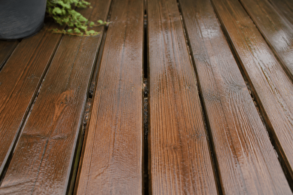 Lames de terrasse mal espacees avec drainage defaillant visible
