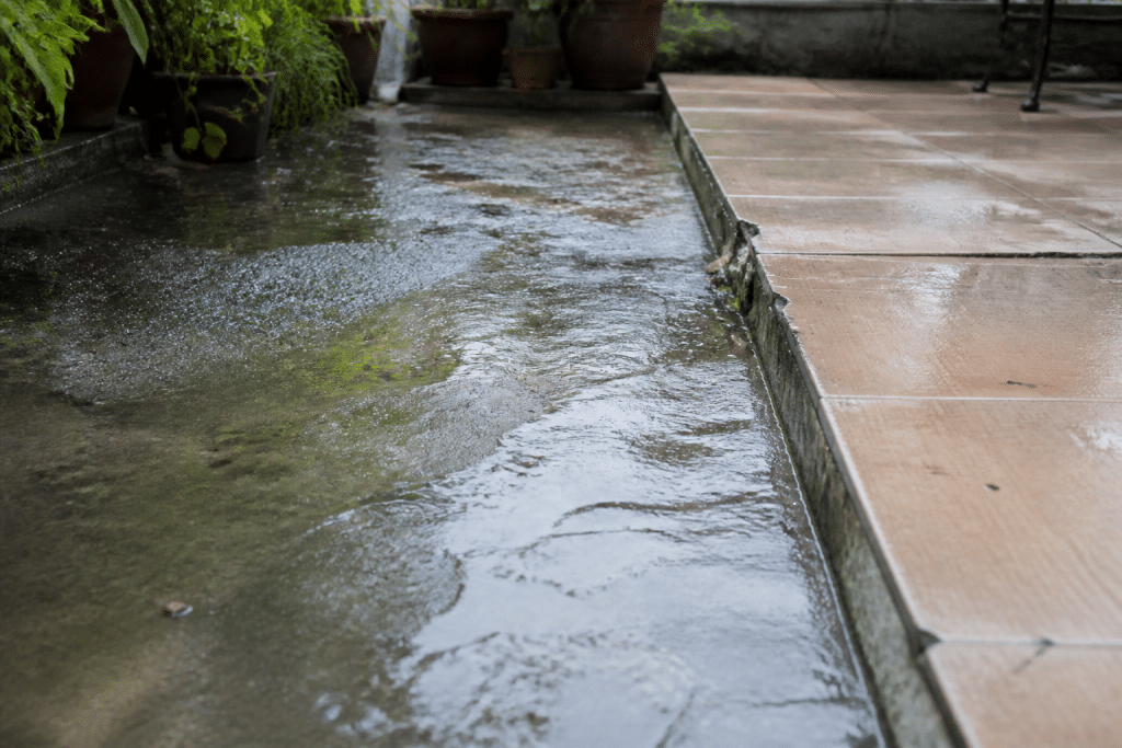 Terrasse mouillée avec zones usées et dégradées visibles