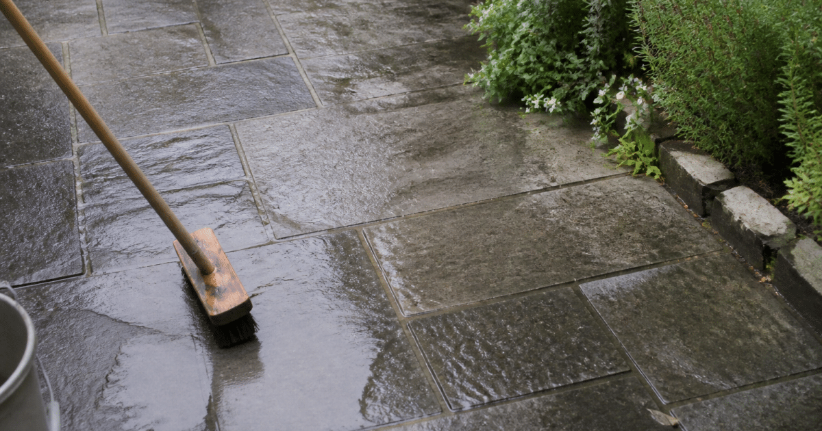 Terrasse en pierre grise nettoyee avec brosse et eau