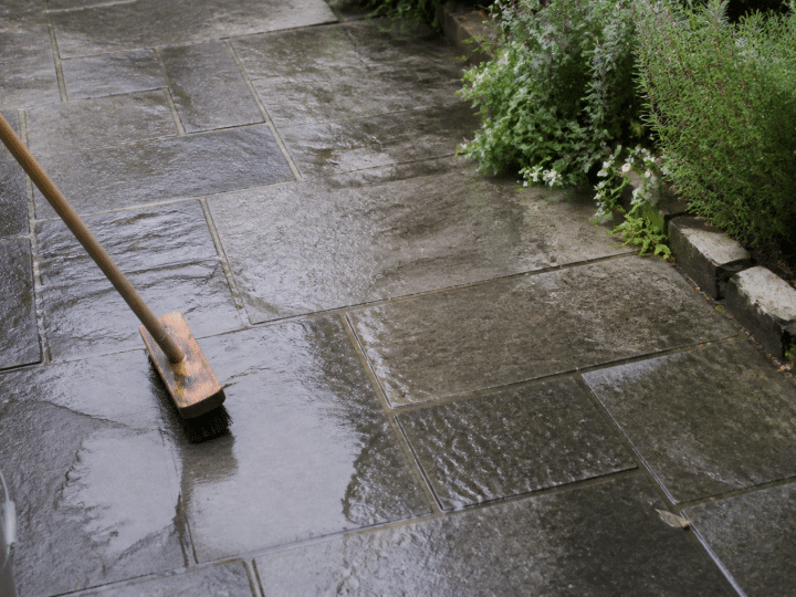 Terrasse en pierre grise nettoyee avec brosse et eau