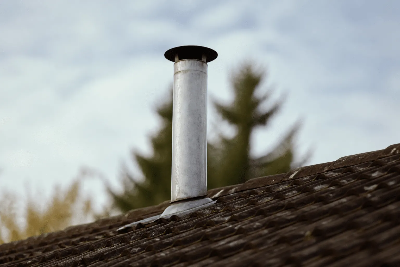 Tuyau metallique vertical sortant du toit incline