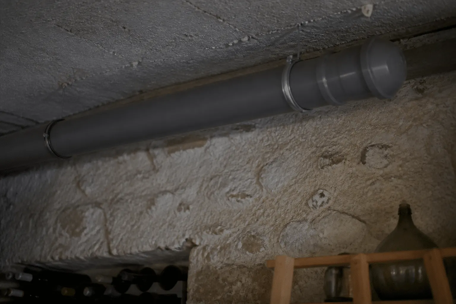 Tuyau ventilation installe horizontalement sous plafond cave
